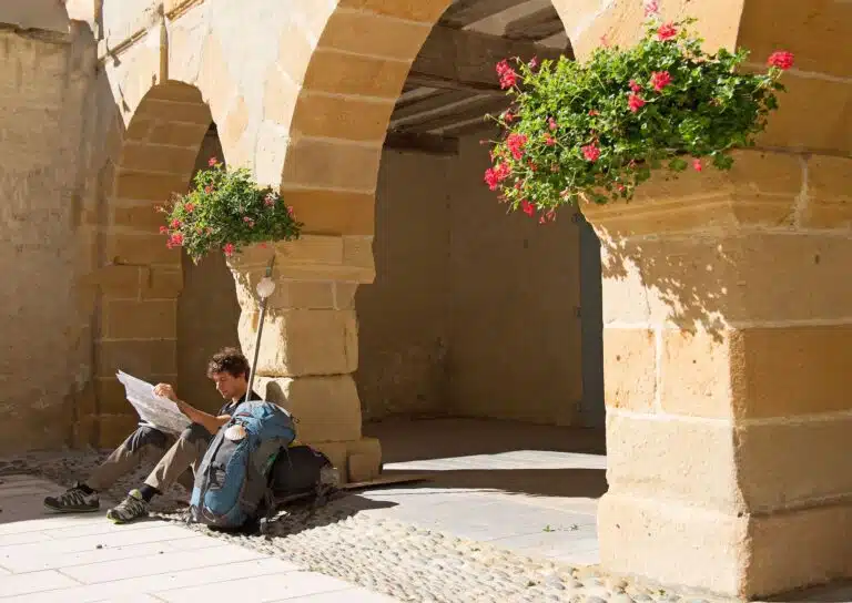 pelerin-compostelle-assis-regarde-plan-en-pause-sous-des-arcades-dans-la-ville-de-Navarrenx