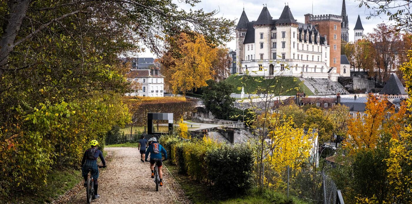 Cycliste en VTT sur le chemin Henri IV à Pau avec le château de Pau en fond à l'automne